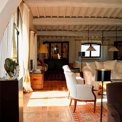 Living room with stone fireplace and view into another room, designed by Archidomus architect Monica Rossi.